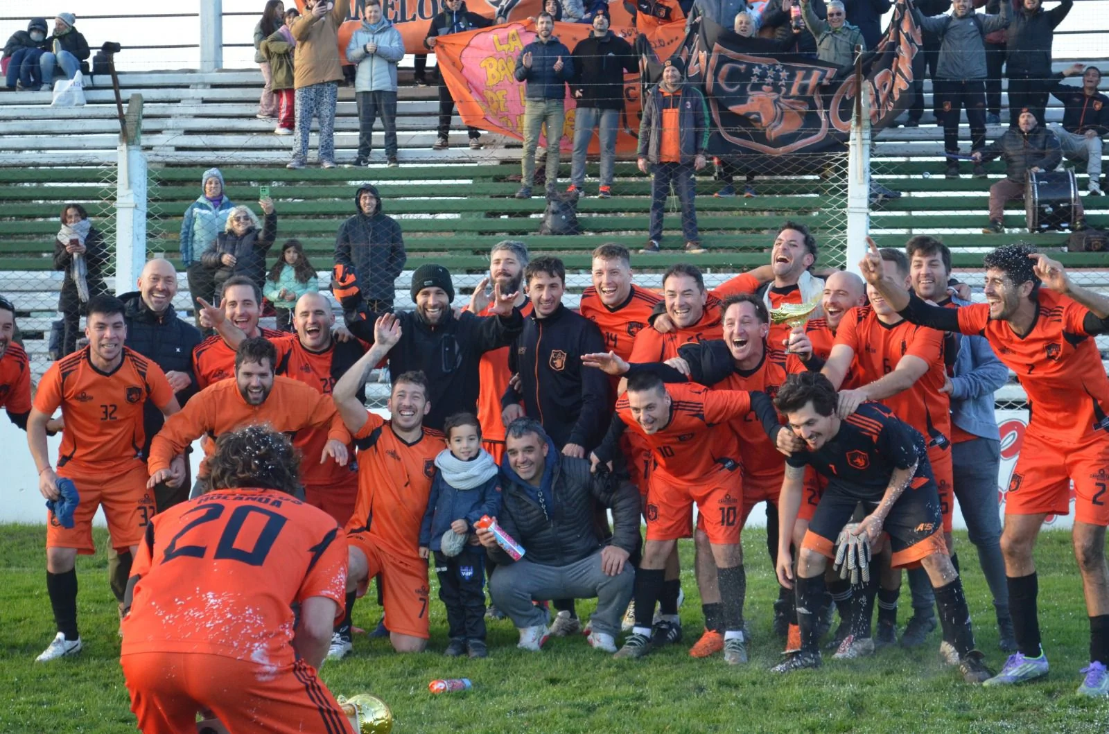 Jugadores, familias y amigos de Caramelos Holanda reunidos en la cancha